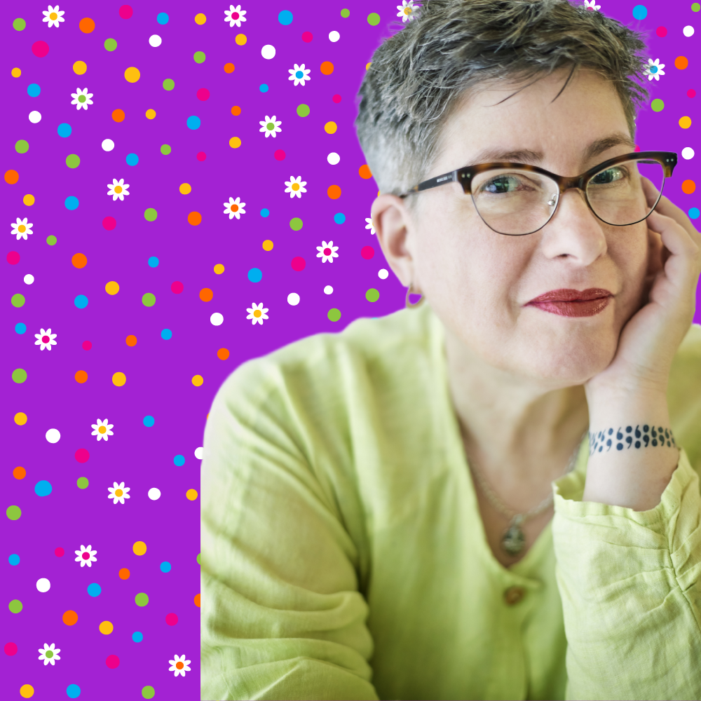 photo nan tepper founder creator of not dead yet app-nan-short brown hair with a little gray wearing cateye eyeglass frame, chin resting on left hand red liptstick wearing a lime green linen blouse with long sleeves